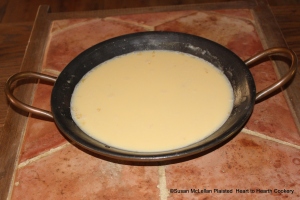 After the boiling hot milk has been gently poured into the basin with the sack and eggs for the receipt (recipe) To make a Sack Posset take it off the Coals.