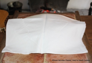 After the basin has been removed from the coals and covered with a dish for the receipt (recipe) To make a Sack Posset lay a cloth over it  and let it stand about a Quarter of an Hour.