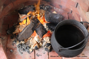 As it was not possible to create the blackhouse earthen floor hearth with a few slab stones set in the middle of the living room to cook the oat bannocks, brick was laid outside on the ground to safely burn the smokey peat fire with its definite aroma.  Historiaclly, the most frequent smoke escape in Scottish blackhouses  was a hole in the roof not even placed directly over the hearth.  Thus much of the smoke rose and settled in the top of the family area and the air would stay relatively clear near the floor.  This writer has first hand experience as I started a peat fire in a recreated blackhouse at The Highland Folk Museum near Kingussie, Scotland.