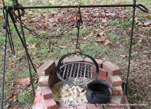 The outside hearth for the peats was made to be similar to the hearth in a Scottish blackhouse by the use of a slabhraidh (iron chain) that could be looped up or let to hang straight down close to the fire as the cooking process demanded. Whether the chain was thick or thin gave a indication of a person's financial status as iron had to be purchased and it was a luxury.  Hanging from the iron chain is a barred girdle for the bannocks and the always necessary iron pot.